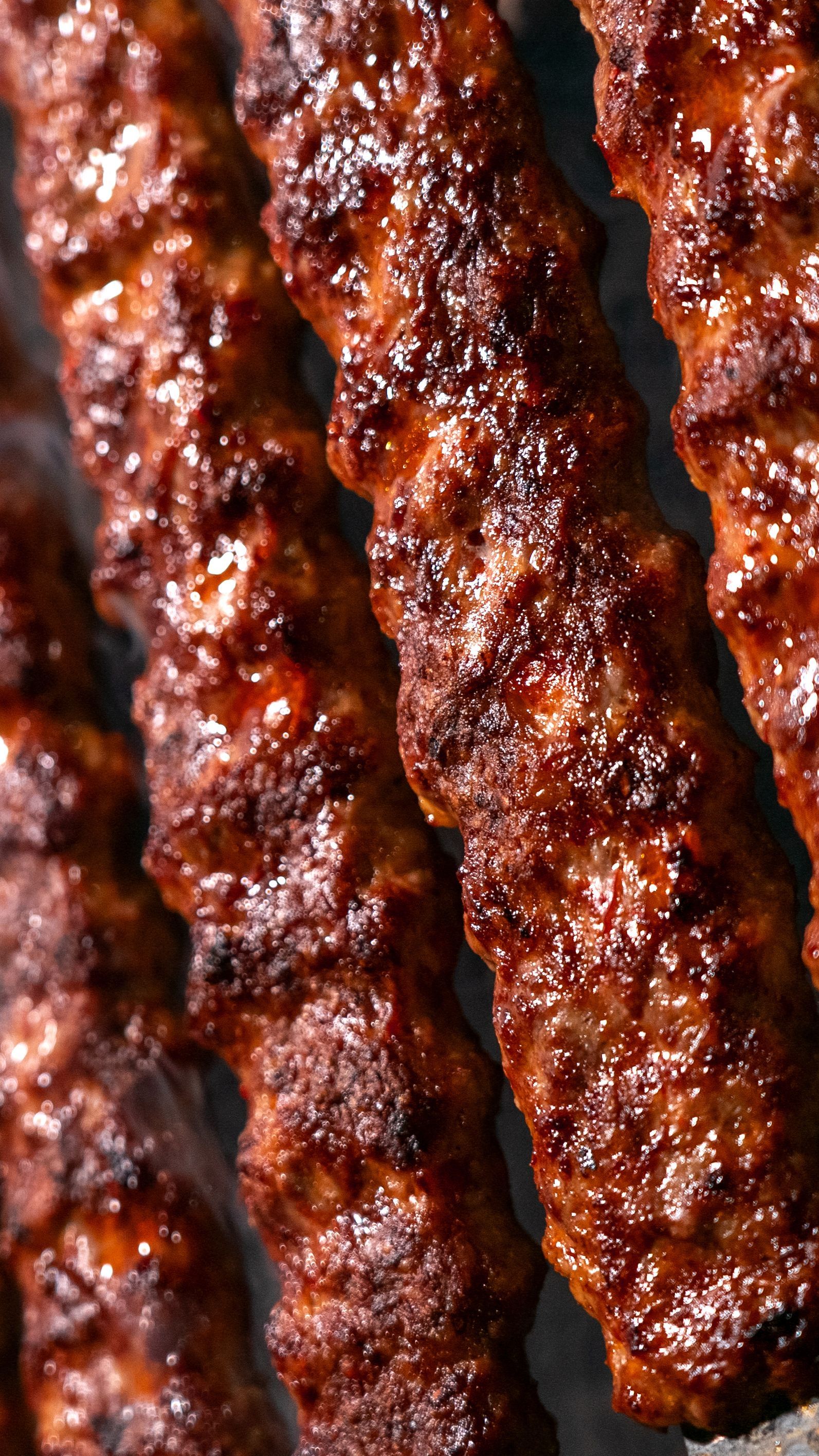 Delicious close-up of sizzling grilled kebab skewers with rich textures and flavors perfect for culinary promotions.