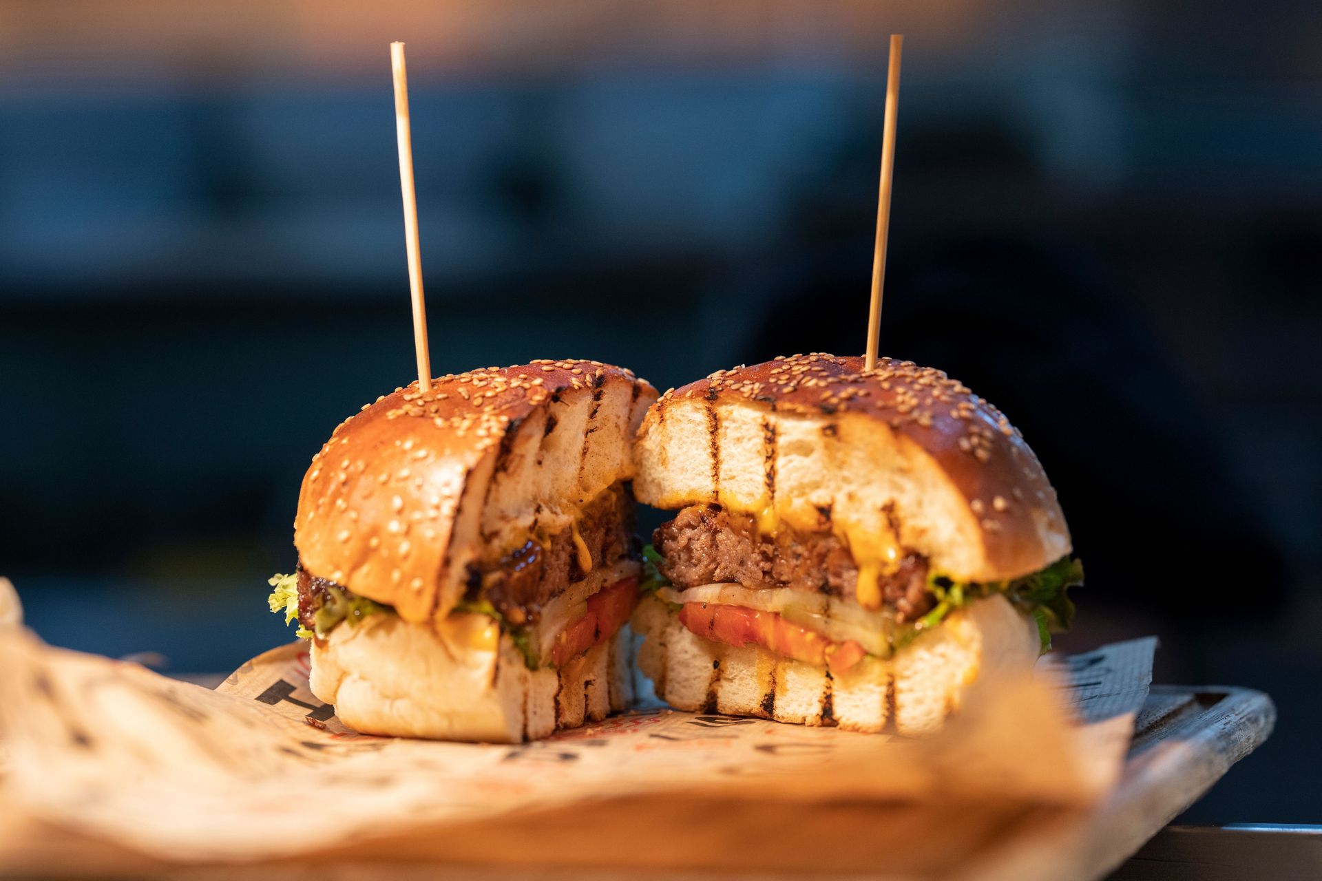 Close-up of a gourmet burger sliced in half, showcasing fresh ingredients and juicy details.