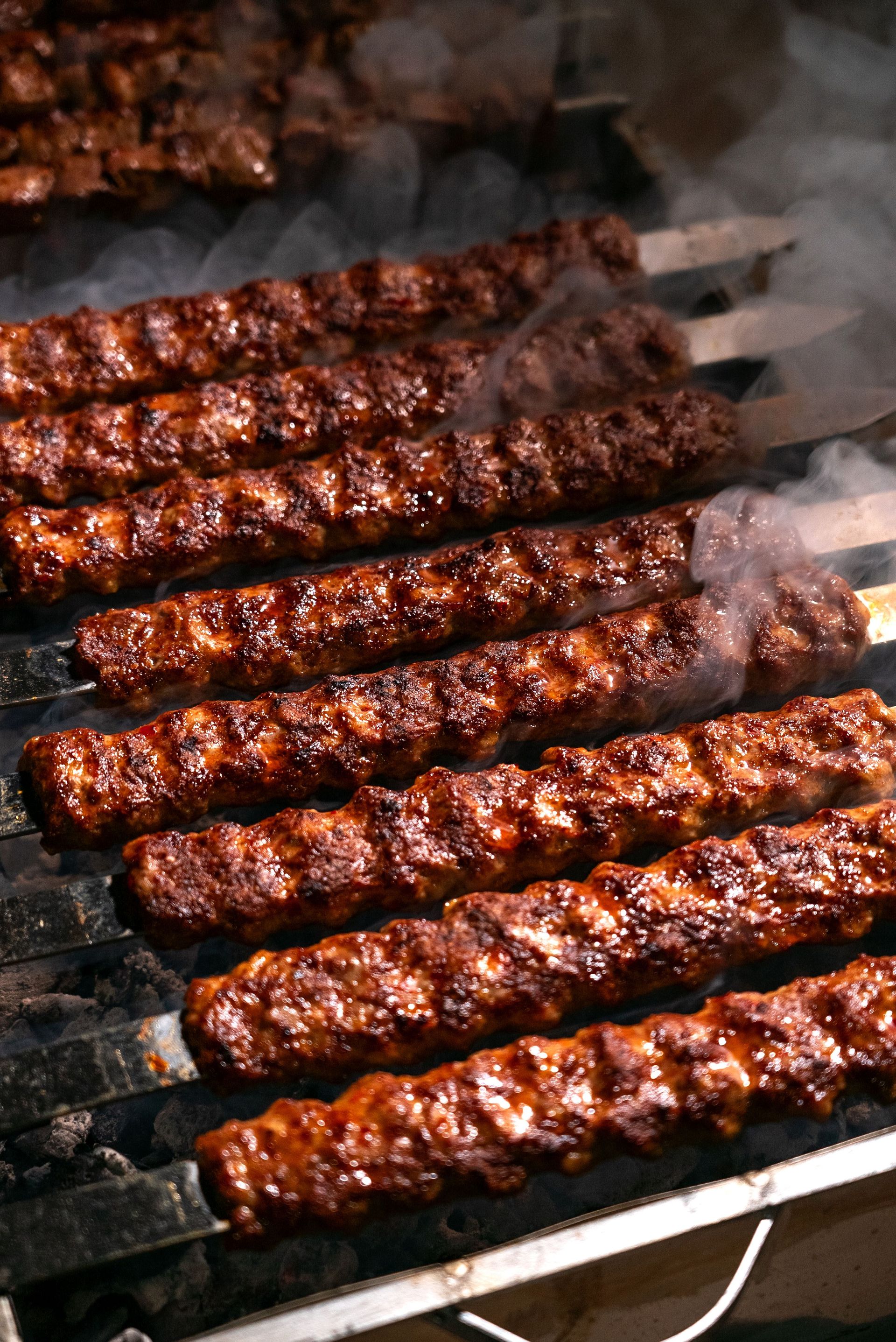 Close-up of sizzling grilled kebabs on a barbecue grill, exuding mouthwatering aroma.